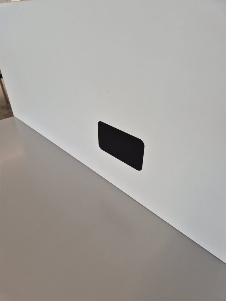 Black 3D-printed cover fitted into a white panel.