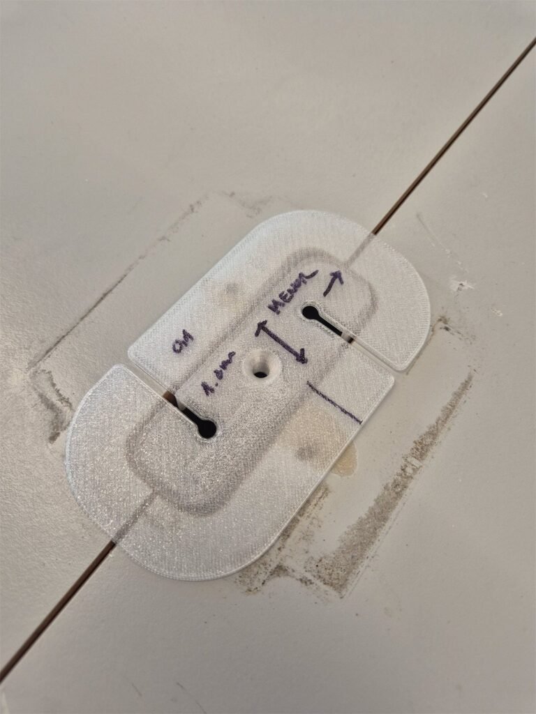 Translucent 3D-printed test piece with handwritten notes, laid over a table top.